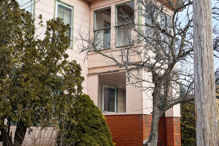 Cream and pink painted two-story Sanford clinic building with brick foundation and bare winter branches